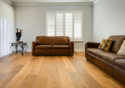 French oak wood flooring in open living lounge room with leather couches