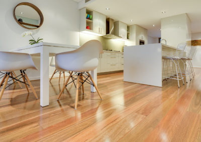 Spotted gum floorboards running parallel with kitchen