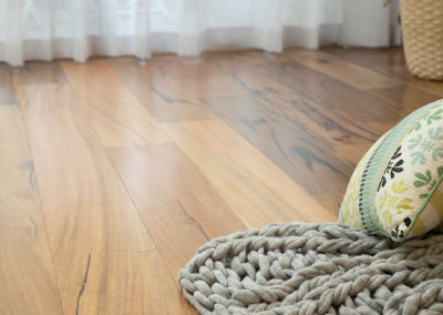 knitted rug, cushion and plant sitting on Marri timber floor