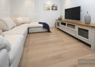 Oak flooring used in living area with tv and sofa
