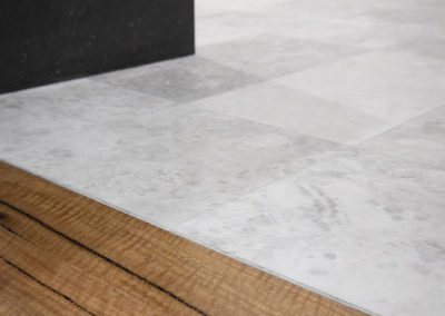 bathroom tiles meet Marri timber flooring in Master bedroom on Perth home